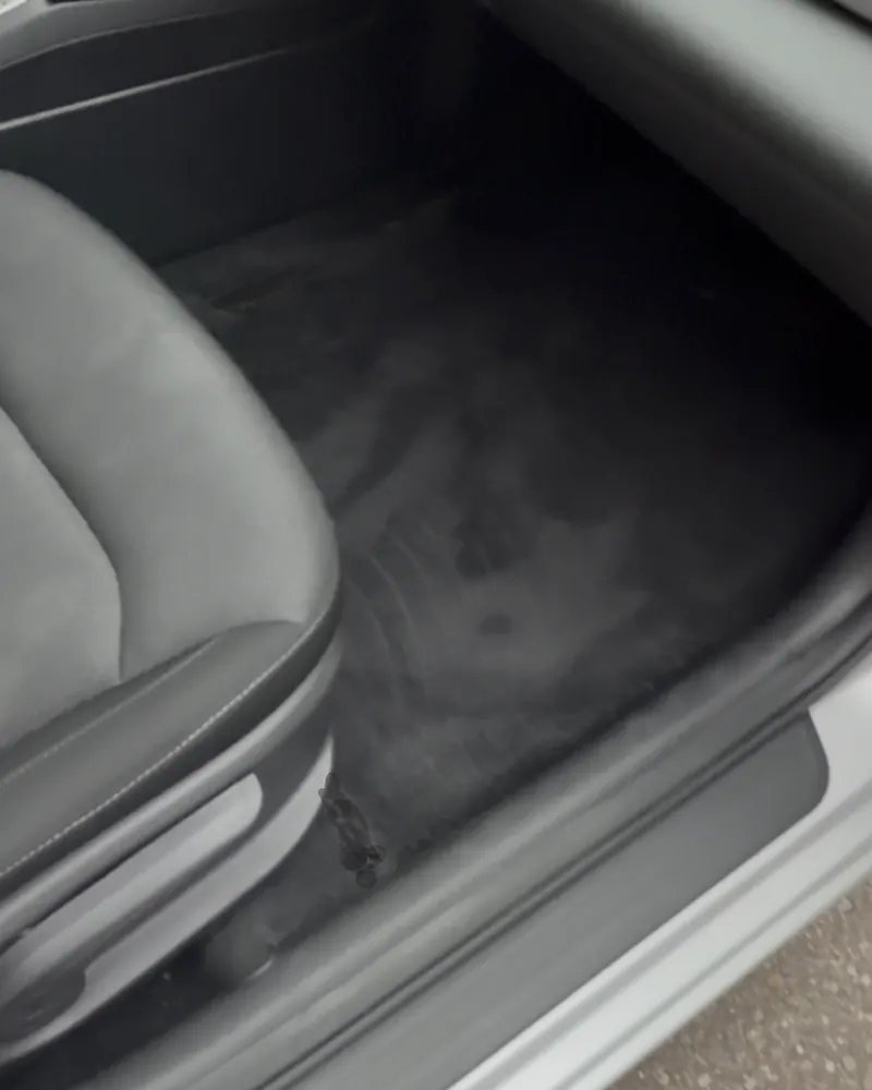 The same passenger footwell after an interior deep clean, carpet dark and even with the salt staining gone