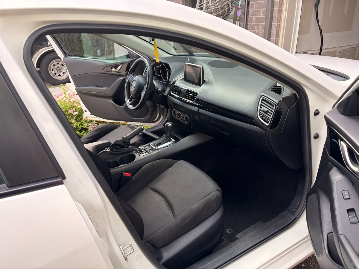 Cloth front seat, dashboard and centre console of a white sedan left clean and dust-free after a deep interior clean