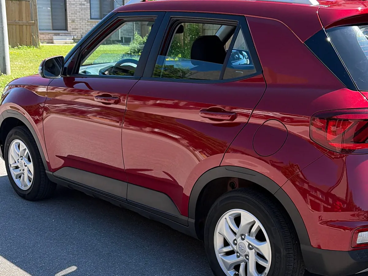 Red compact SUV in a driveway after an express clean, exterior hand-washed and paint left clean
